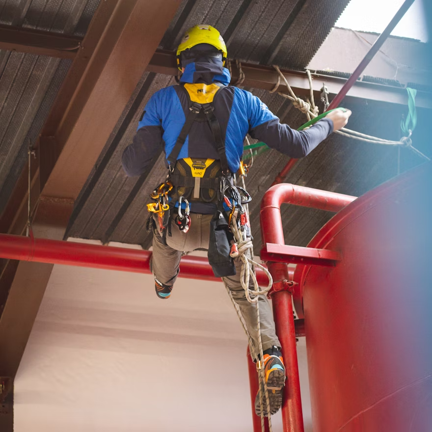 A worker performing rope access maintenance.