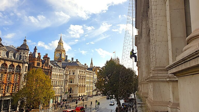 Rope access technician installing bird netting